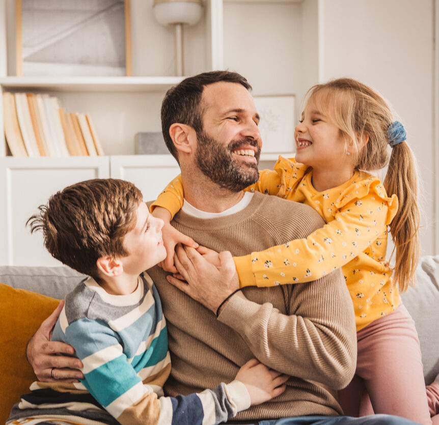 Happy kids hugging father and showing him love for father's day.
